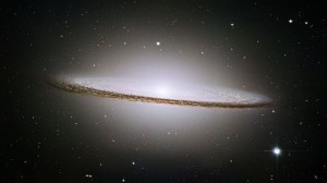 a photo of an edge-on spiral galaxy with a thick dust lane
