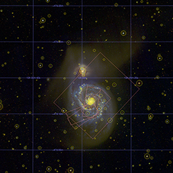 A large galaxy next to a smaller galaxy, with nearby objects marked by circles